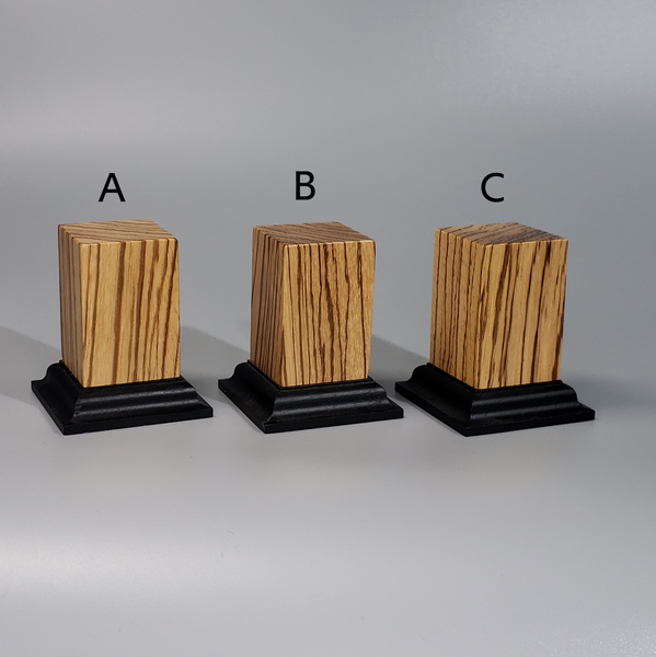 three wooden pedestals with black bases on a gray background