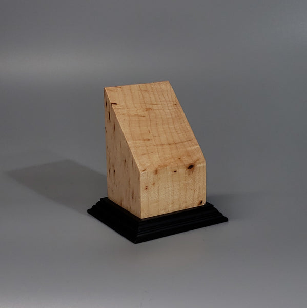 a piece of wood sitting on top of a black base