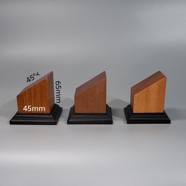 three wooden sculptures on black bases on a white background